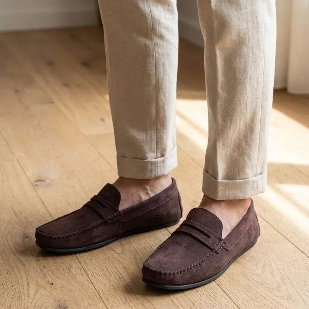 Mocassim Driver de Camurça Capri Tobacco na cor marrom-escuro, usado com calça clara de barra dobrada. Louford.