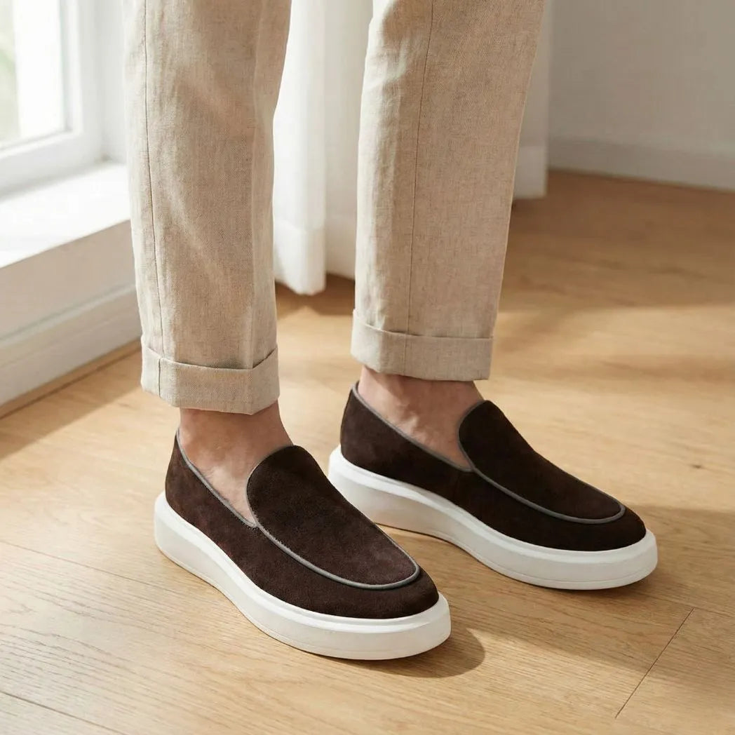 Mocassim Loafer de Camurça Vanguard: par marrom-escuro com sola branca usado com calça bege dobrada na barra. Louford.