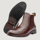 Par de botas Chelsea Milan marrons, com um dos solados voltado para a câmera.