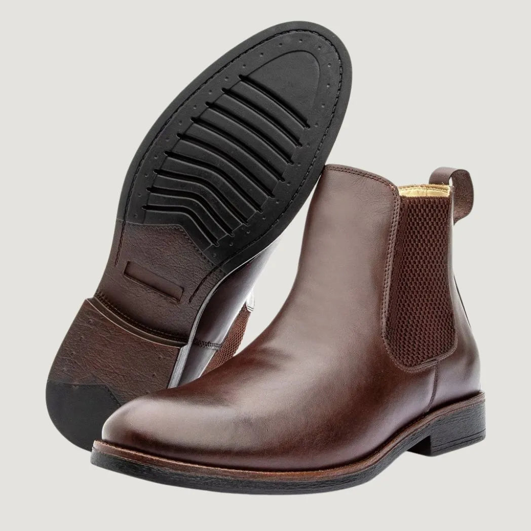 Par de botas Chelsea Milan marrons, com um dos solados voltado para a câmera.