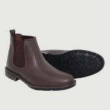 Par de botas Chelsea Sítio marrons, com um dos solados voltado para a câmera.