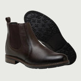 Par de botas Chelsea Vitiello marrons, com um dos solados voltado para a câmera.