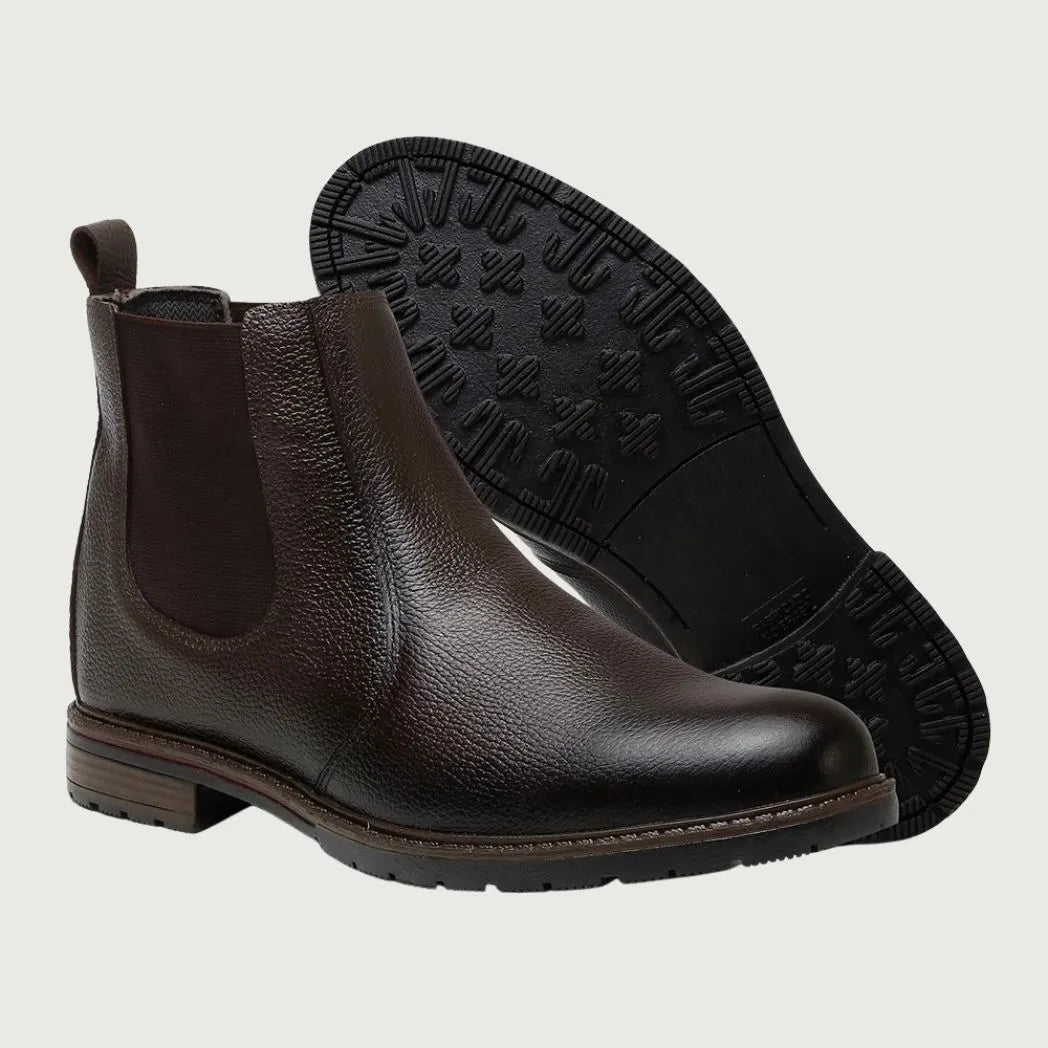 Par de botas Chelsea Vitiello marrons, com um dos solados voltado para a câmera.