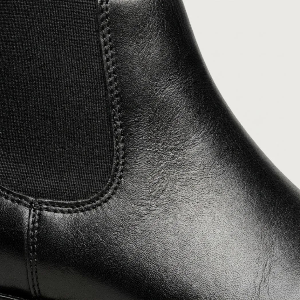 Detalhe do elástico lateral e das costuras da Bota Chelsea Masculina Clássica preta.