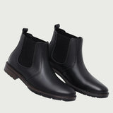 Par de botas Chelsea Sítio pretas em perspectiva, com elásticos laterais visíveis.