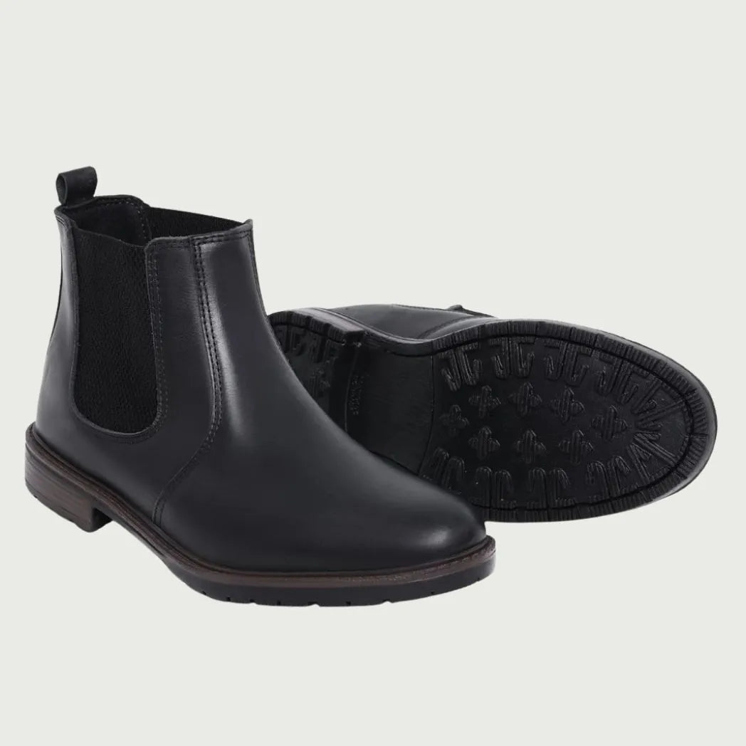 Par de botas Chelsea Sítio pretas, com um dos solados voltado para a câmera.