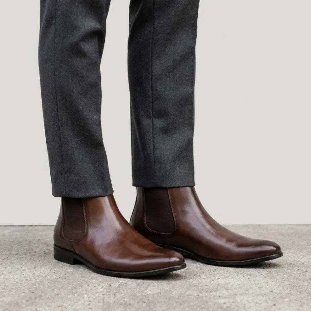 botas Chelsea Nobre marrons usadas com calça cinza de barra dobrada.