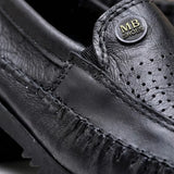 Mocassim Casual Air Ventus: detalhe da superfície preta perfurada, do emblema circular e da costura frontal.