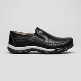 Mocassim Casual Comfort Daytona Drive: modelo preto de perfil, com emblema circular lateral e sola preta e branca.