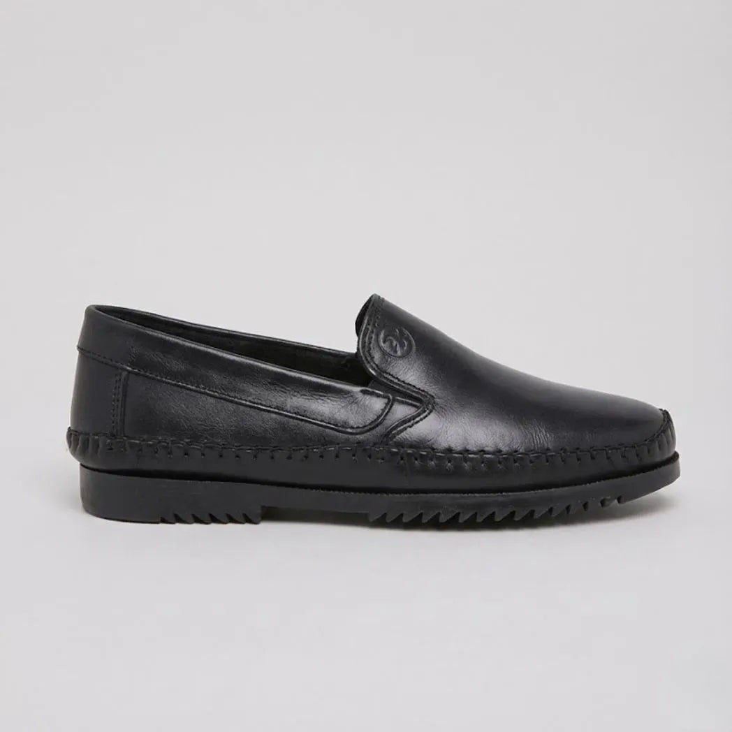 Mocassim Casual Dakota Rust: modelo preto de perfil, com emblema em relevo e sola preta.