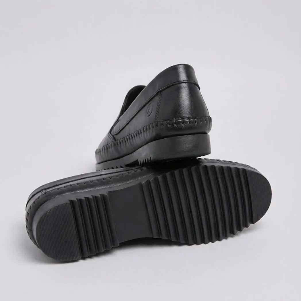 Mocassim Casual Dakota Rust: par preto com um sapato virado, mostrando a sola preta com sulcos.