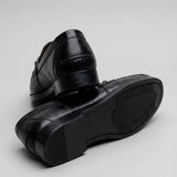 Par do modelo Mocassim Casual Loafer Nero, na cor preto, com um dos solados voltado para a câmera.