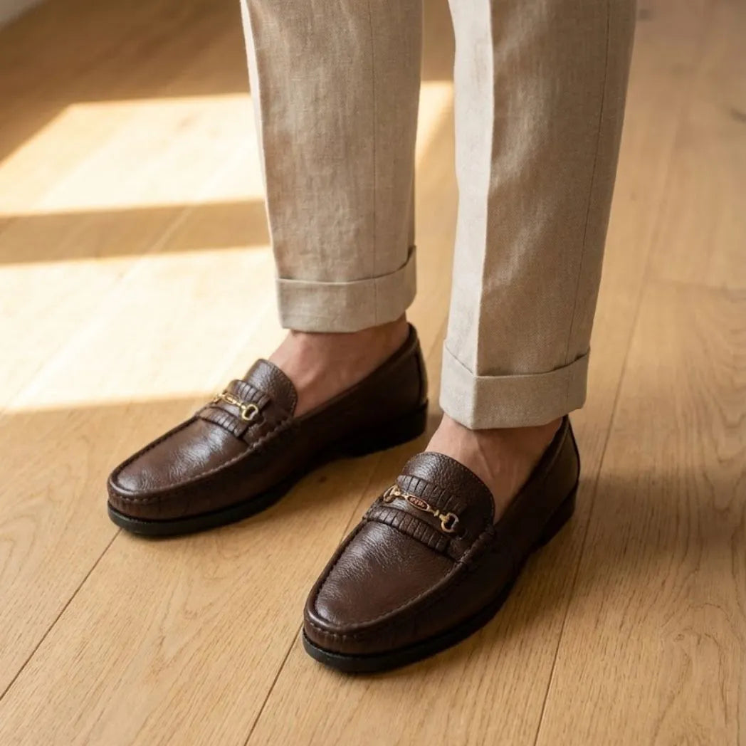 Mocassim Casual Loafer Nero na cor marrom, usado com calça clara de barra dobrada.