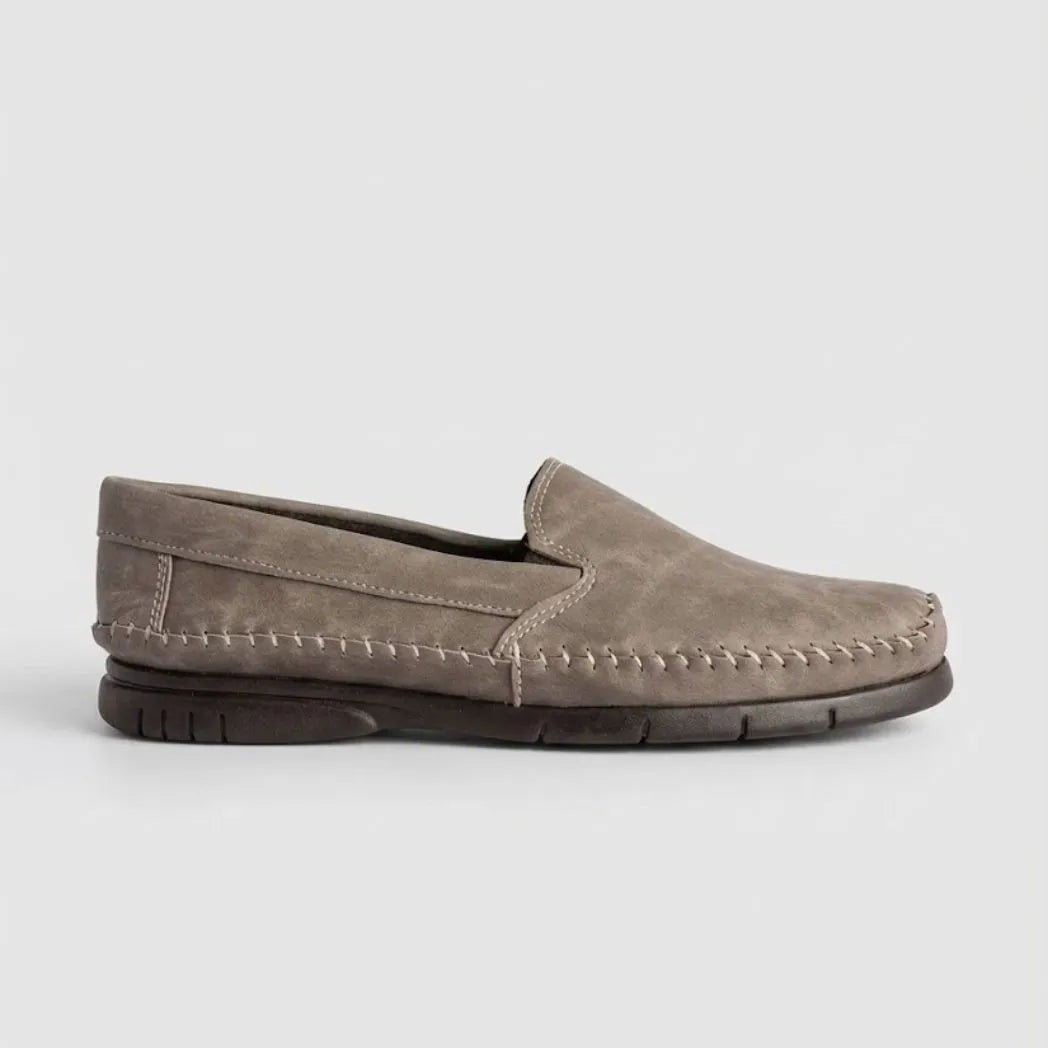 Mocassim Cognac de Couro: modelo cinza de perfil, com faixa frontal, costura clara e sola escura.