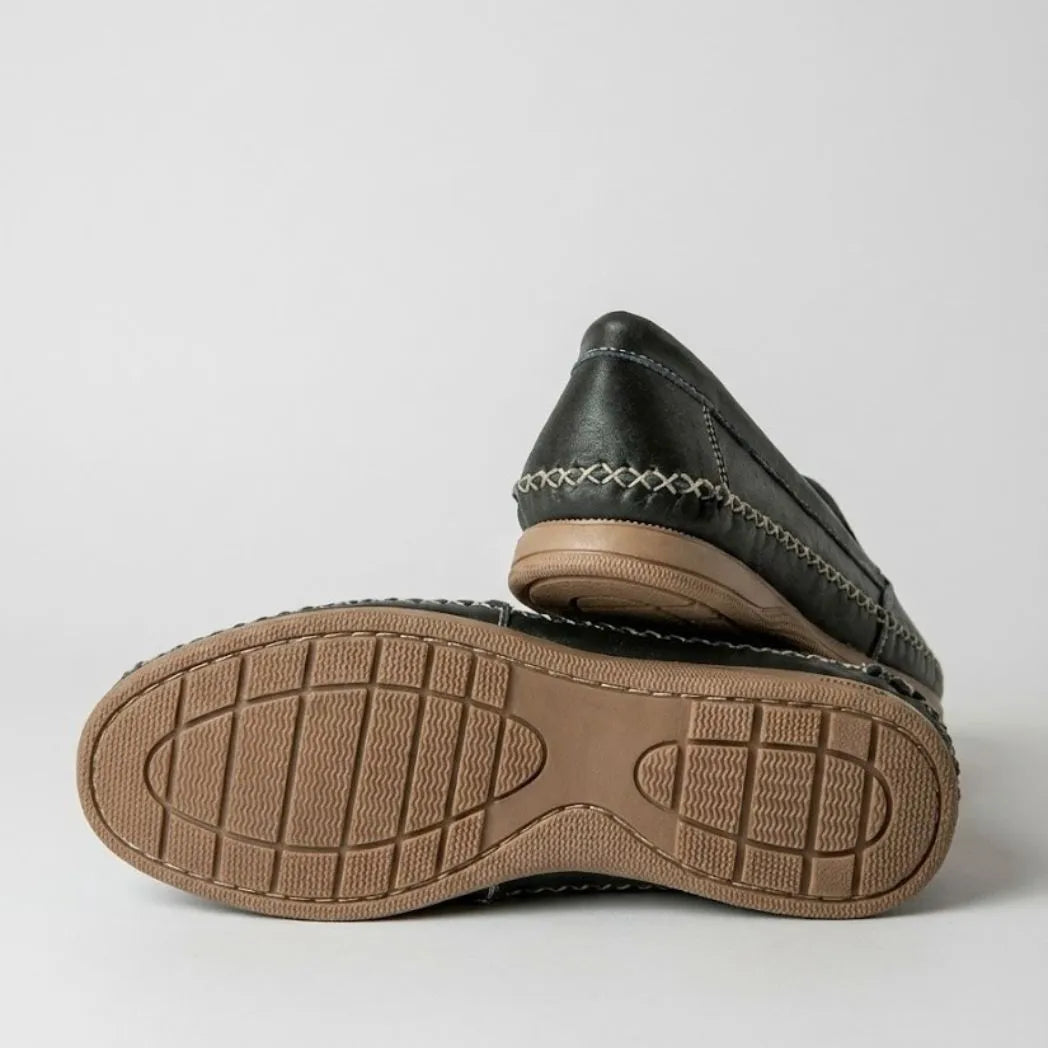 Par do modelo Mocassim Cognac de Couro, na cor preto, com um dos solados voltado para a câmera.