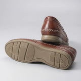 Par do modelo Mocassim Cognac de Couro, na cor marrom-avermelhado, com um dos solados voltado para a câmera.