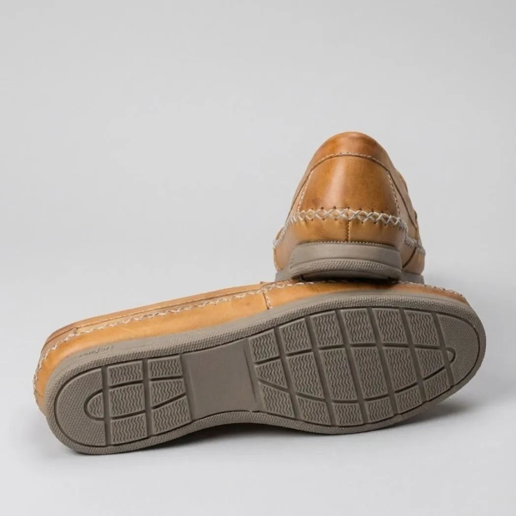Par do modelo Mocassim Cognac de Couro, na cor bege, com um dos solados voltado para a câmera.