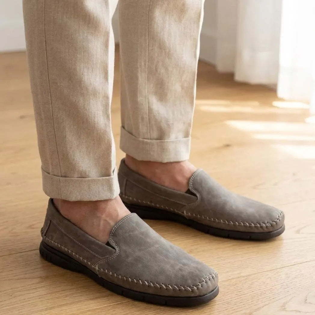 Mocassim Cognac de Couro na cor cinza, usado com calça clara de barra dobrada.