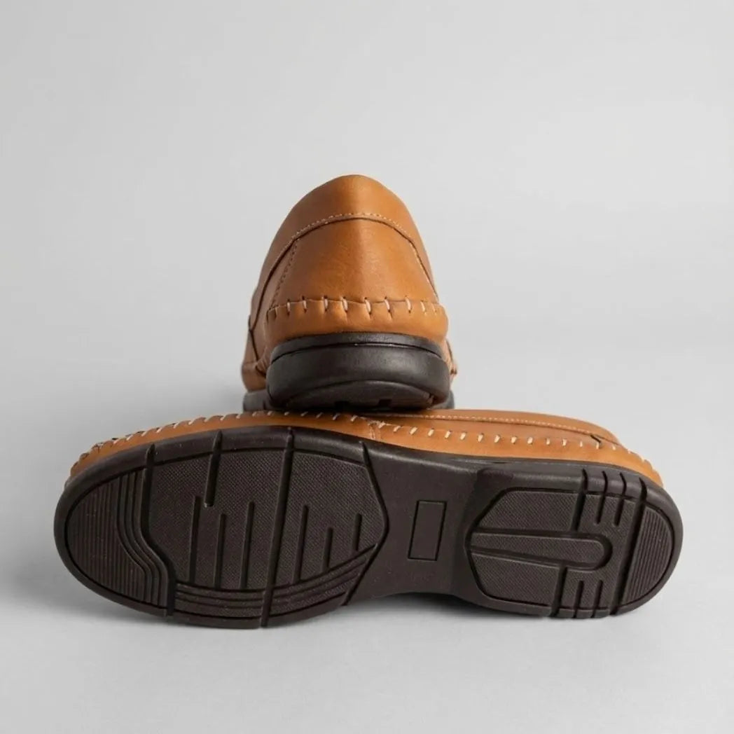 Par do modelo Mocassim Cognac de Couro, na cor laranja, com um dos solados voltado para a câmera.