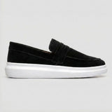 Mocassim Derby de Camurça: modelo preto de perfil, com faixa frontal e sola branca.