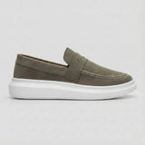 Mocassim Derby de Camurça: modelo verde-oliva de perfil, com faixa frontal e sola branca.