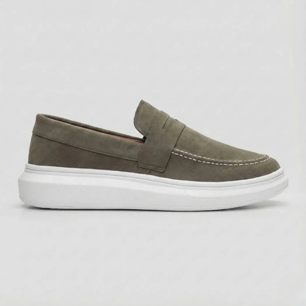 Mocassim Derby de Camurça: modelo verde-oliva de perfil, com faixa frontal e sola branca.