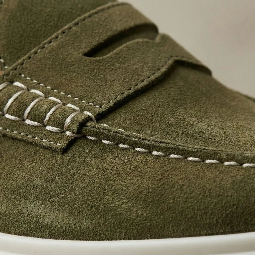 Mocassim Derby de Camurça: detalhe da textura verde-oliva, da faixa frontal e da costura clara.