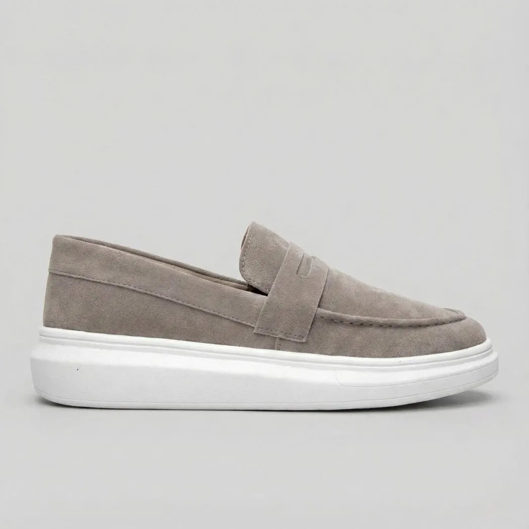 Mocassim Derby de Camurça: modelo cinza de perfil, com faixa frontal e sola branca.