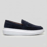 Mocassim Derby de Camurça: modelo azul-escuro de perfil, com faixa frontal e sola branca.