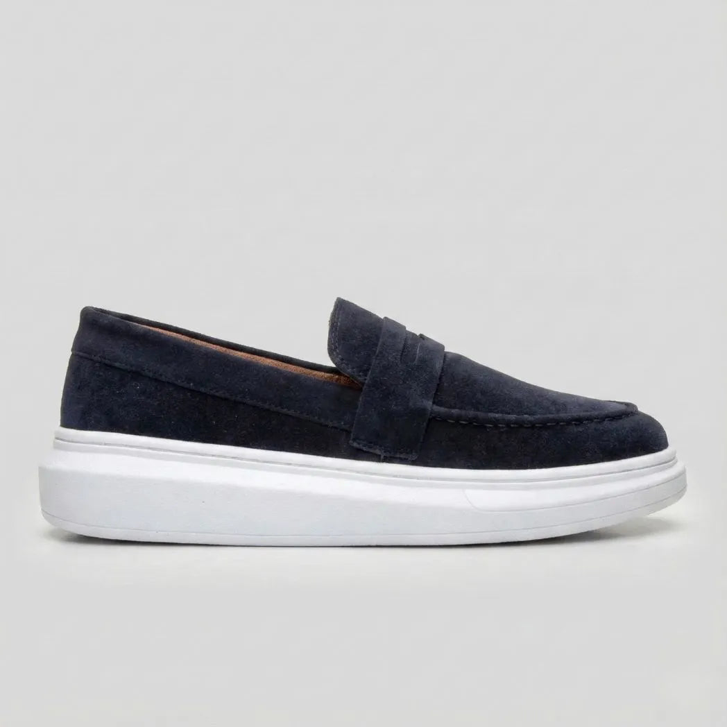 Mocassim Derby de Camurça: modelo azul-escuro de perfil, com faixa frontal e sola branca.