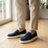 Mocassim Derby de Camurça: par azul-escuro com sola branca usado com calça clara dobrada na barra.