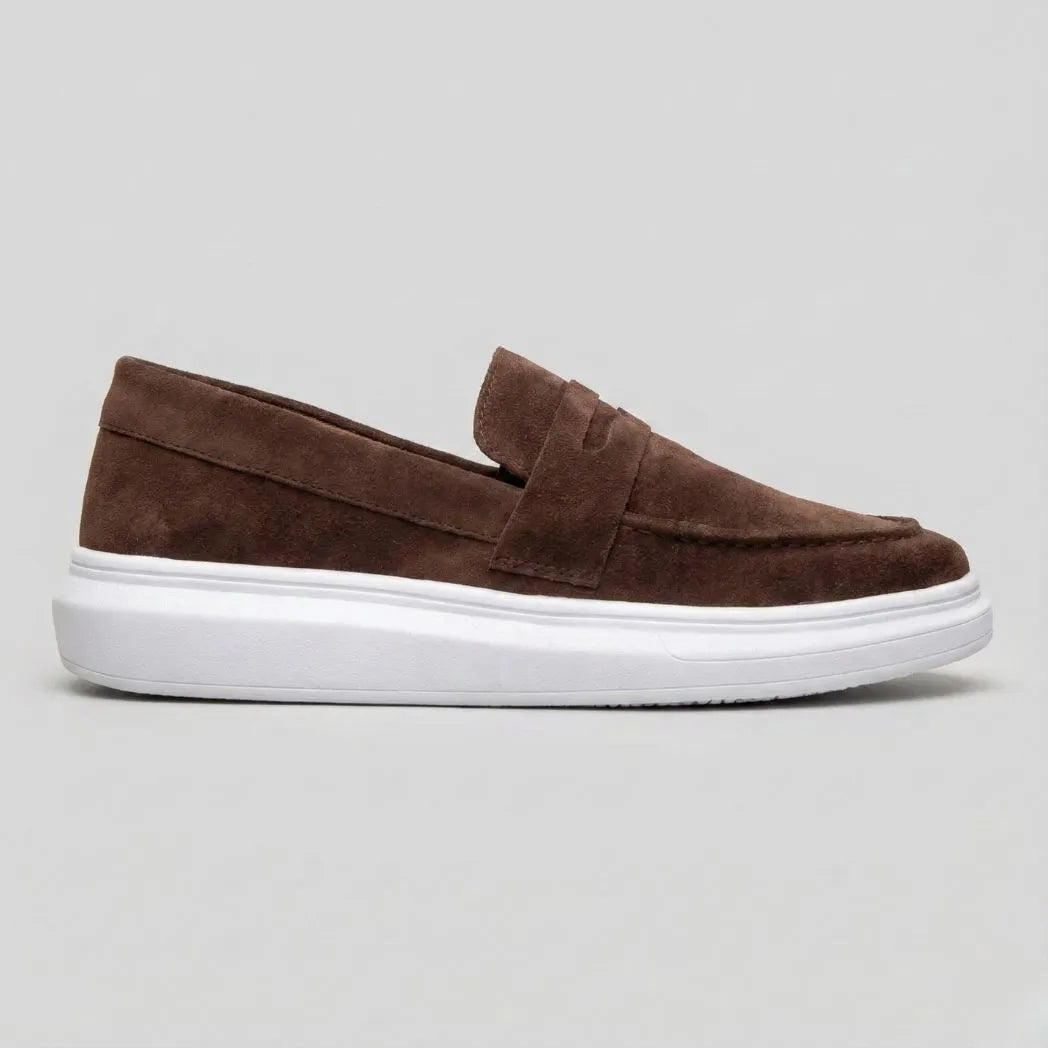 Mocassim Derby de Camurça: modelo marrom de perfil, com faixa frontal e sola branca.