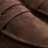 Mocassim Derby de Camurça: detalhe da textura marrom, da faixa frontal e da costura.