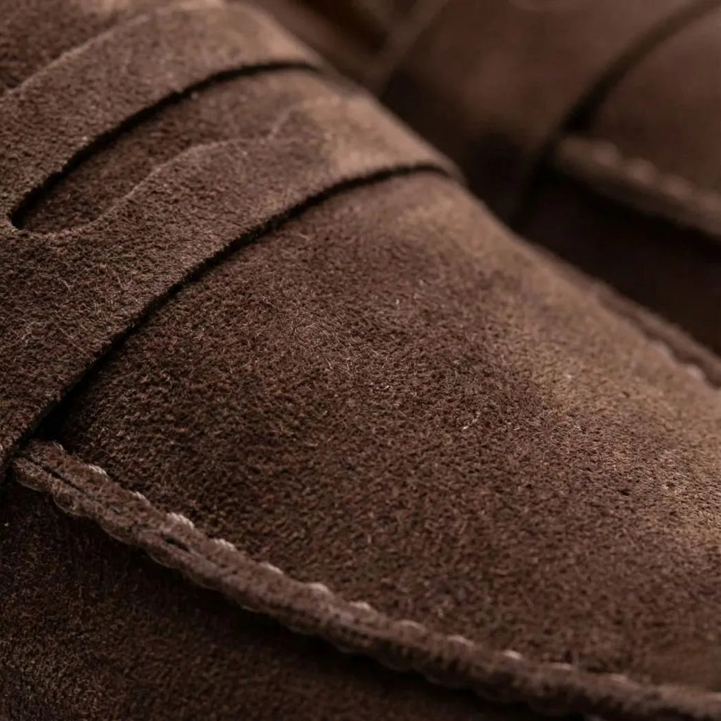 Mocassim Derby de Camurça: detalhe da textura marrom, da faixa frontal e da costura.