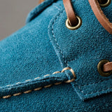 Mocassim Dockside de Camurça: detalhe da textura azul, dos ilhós dourados e da costura frontal.