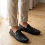 Mocassim Driver Cruise de Couro Preto na cor preto, usado com calça clara de barra dobrada.
