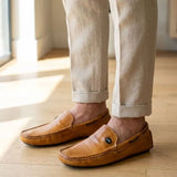 Mocassim Driver Cruise de Couro Laranja na cor laranja, usado com calça clara de barra dobrada.