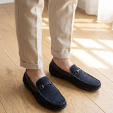 Mocassim Driver Dune de Camurça na cor preto, usado com calça clara de barra dobrada.