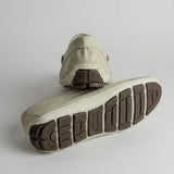 Par do modelo Mocassim Driver Heritage de Couro Branco, na cor branco, com um dos solados voltado para a câmera.