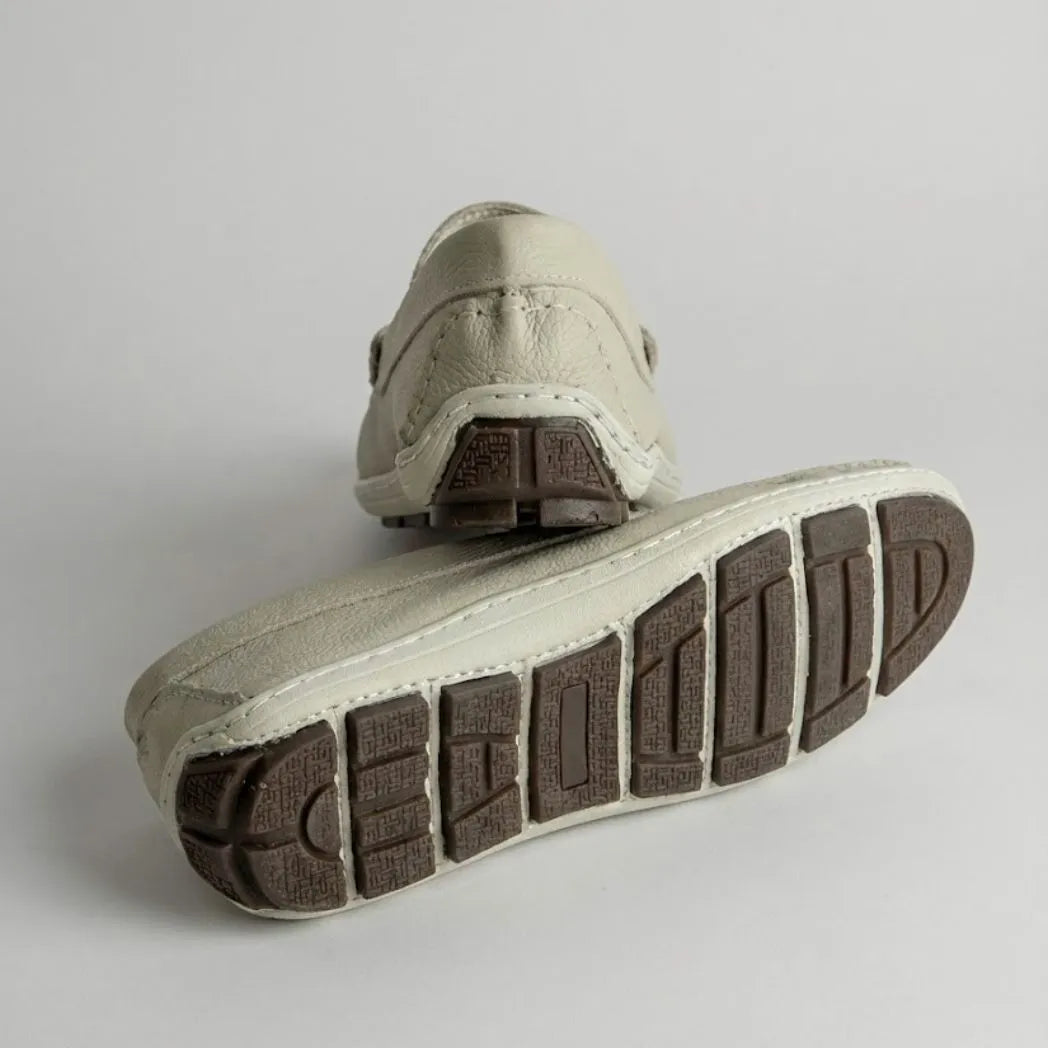 Par do modelo Mocassim Driver Heritage de Couro Branco, na cor branco, com um dos solados voltado para a câmera.