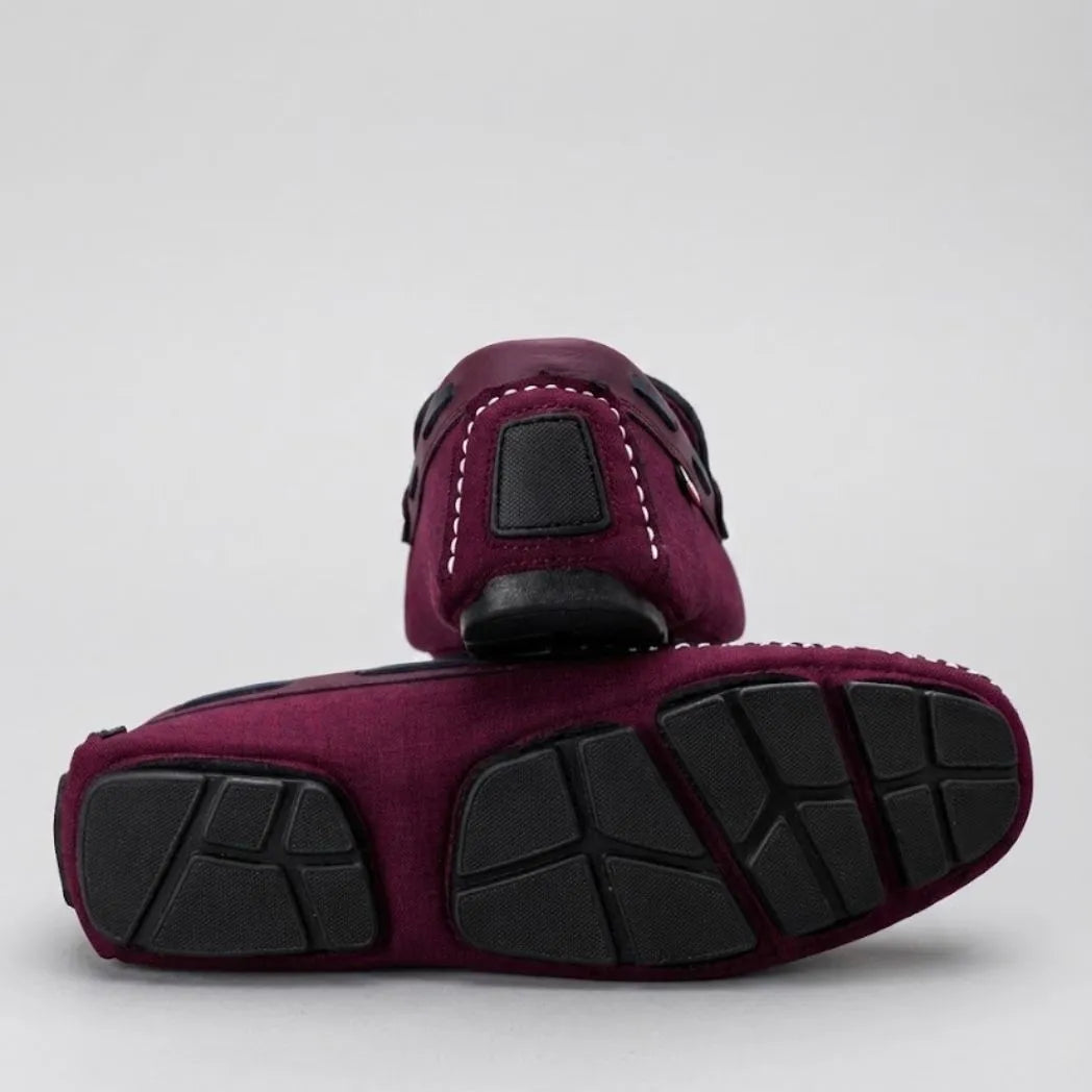 Par do modelo Mocassim Driver Riviera em Lona, na cor bordô, com um dos solados voltado para a câmera.