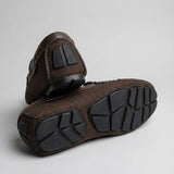 Par do modelo Mocassim Driver Riviera em Lona, na cor marrom, com um dos solados voltado para a câmera.