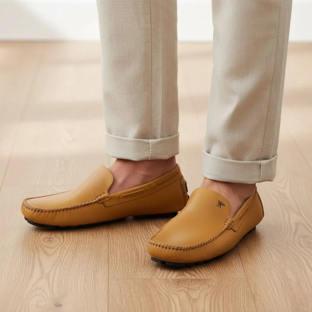 Mocassim Driver Vancouver de Couro na cor caramelo, usado com calça clara de barra dobrada.