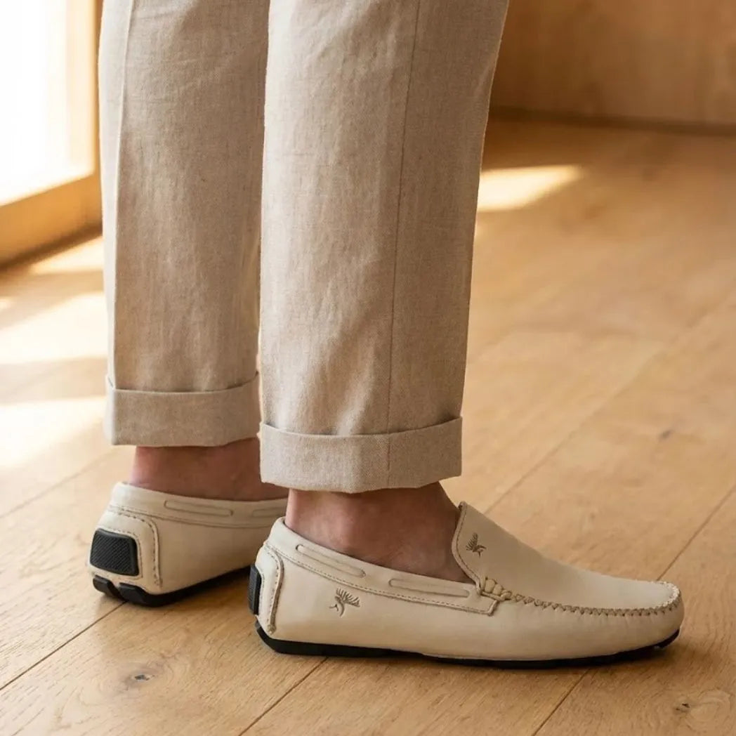 Mocassim Driver Vancouver de Couro na cor branco, usado com calça clara de barra dobrada.