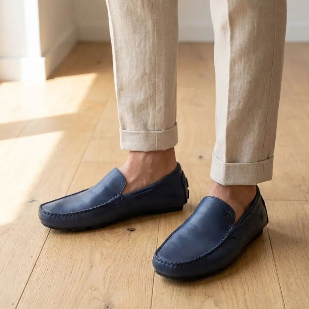Mocassim Driver Vancouver de Couro na cor azul, usado com calça clara de barra dobrada.