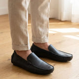 Mocassim Driver Vancouver de Couro na cor preto, usado com calça clara de barra dobrada.