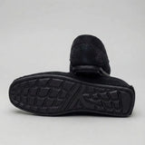 Mocassim Driver de Camurça Aspen Ice: par preto com um sapato virado, mostrando a sola preta com sulcos.