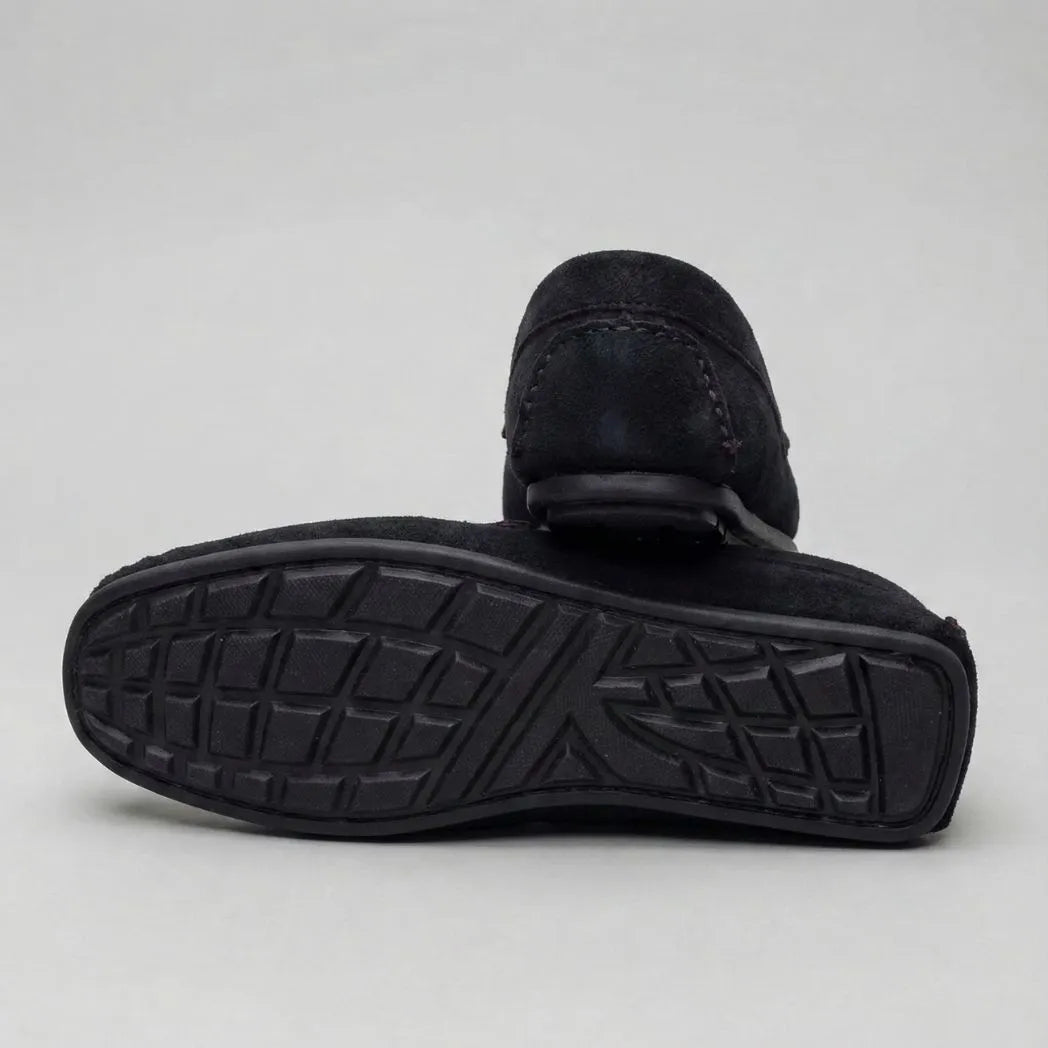 Mocassim Driver de Camurça Aspen Ice: par preto com um sapato virado, mostrando a sola preta com sulcos.