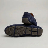 Par do modelo Mocassim Driver de Camurça Capri Dune, na cor azul-escuro, com um dos solados voltado para a câmera.