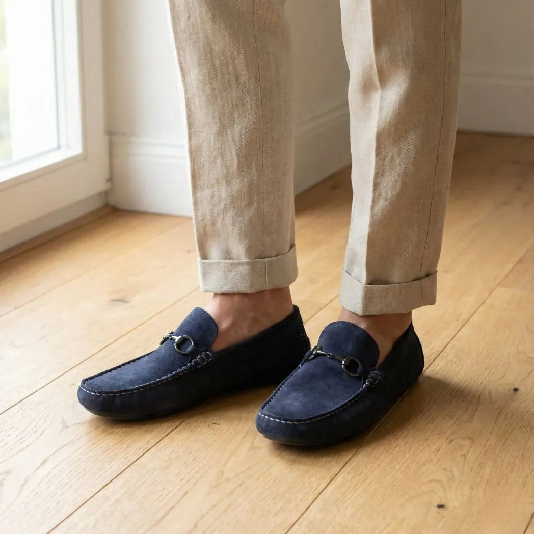 Mocassim Driver de Camurça Capri Dune na cor azul-escuro, usado com calça clara de barra dobrada.